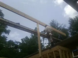 Carpenter setting a ridge beam over a new addition frame — Ice Dam Removal by Roofing Brothers in Shafer
