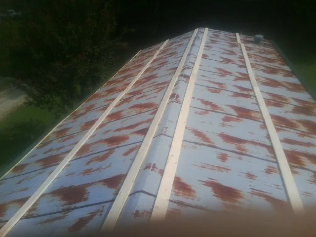 Rusted metal roof panels with new wood purlins before replacement — Storm Damage Roof Repair in Shafer by Roofing Brothers